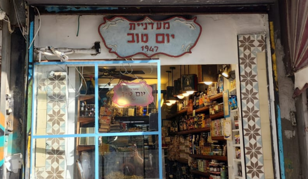 Storefront of Yom Tov Delicatessen on Levinsky Street in Levinsky Market, Tel Aviv, a historic Turkish Jewish deli run by three generations of the Levi family and a featured stop on Levinsky Market food tours, known for traditional cheeses, pickles, and Turkish Jewish delicatessen craftsmanship in Israel