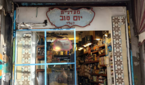 Storefront of Yom Tov Delicatessen on Levinsky Street in Levinsky Market, Tel Aviv, a historic Turkish Jewish deli run by three generations of the Levi family and a featured stop on Levinsky Market food tours, known for traditional cheeses, pickles, and Turkish Jewish delicatessen craftsmanship in Israel