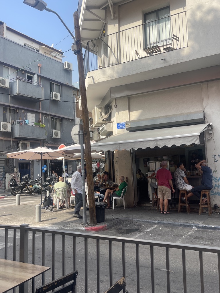 Regulars gathered outside Matti's Bar in Florentin Tel Aviv sitting and kibitzing at sidewalk tables near Levinsky Market.
